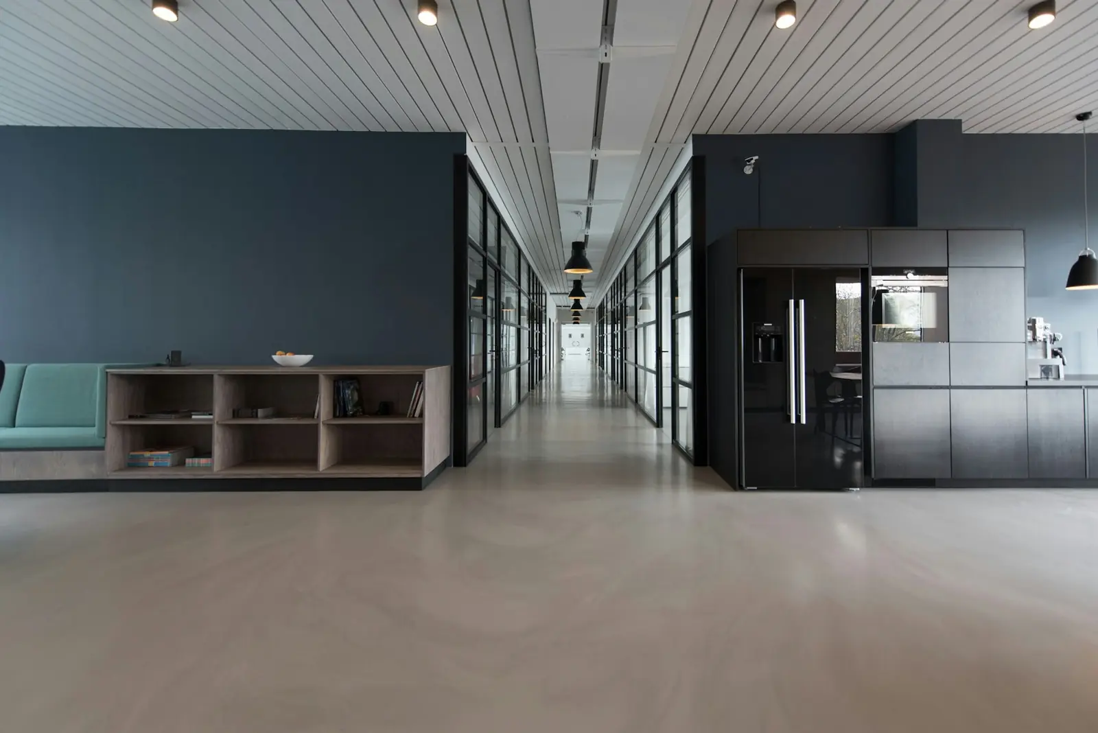 Long office interior with glass rooms and a quiet corridor