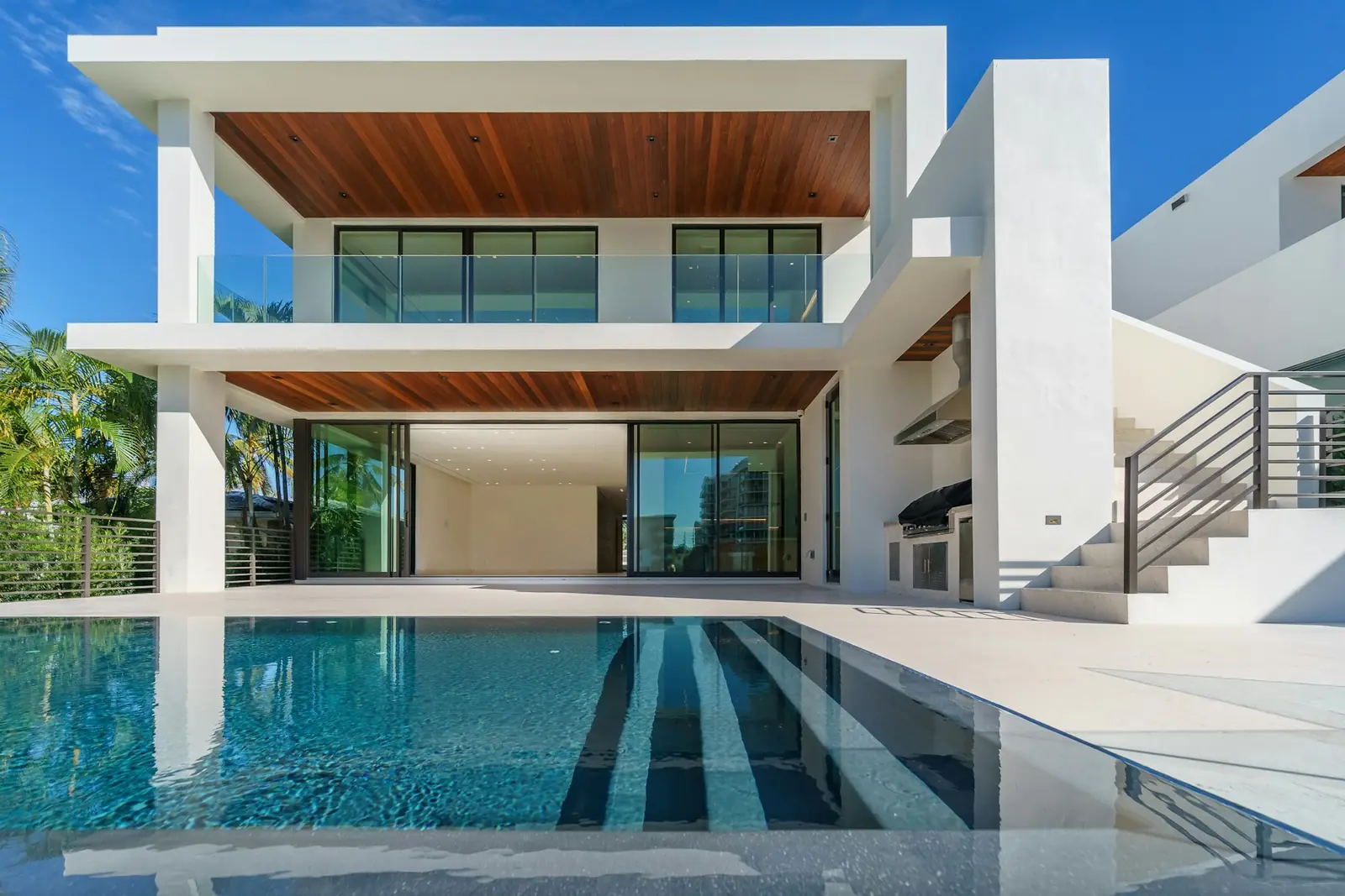 White house with a pool and palms